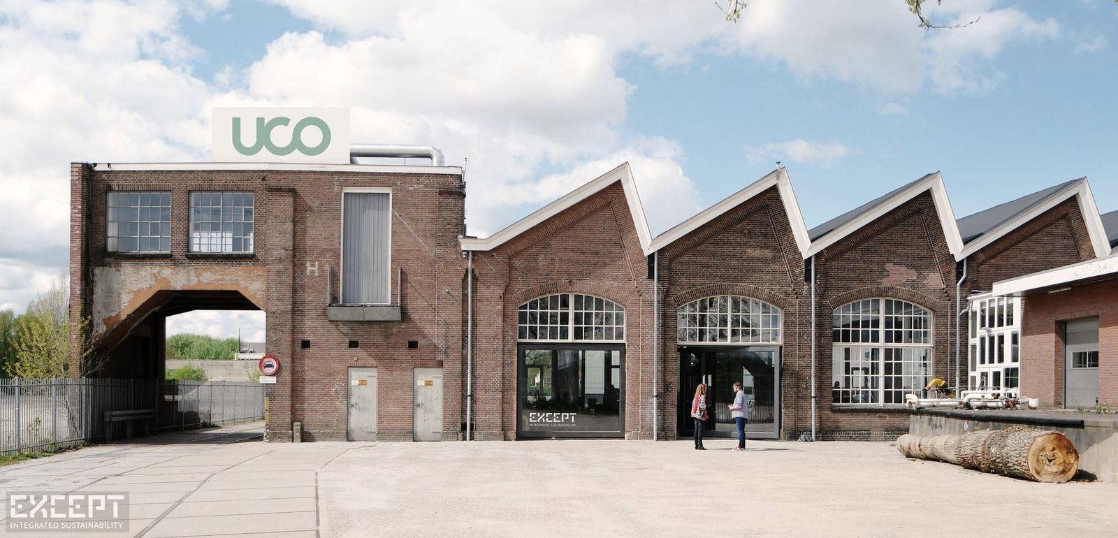 The Utrecht Community building seen from the yard, a row of brick industrial halls under a wide sky.